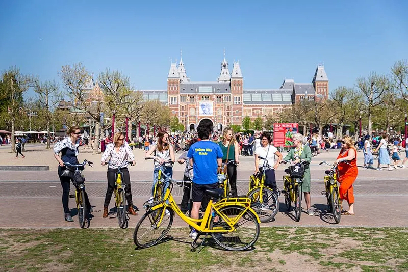 bike tour in amsterdam stopping at museum square with rijksmuseum in the background