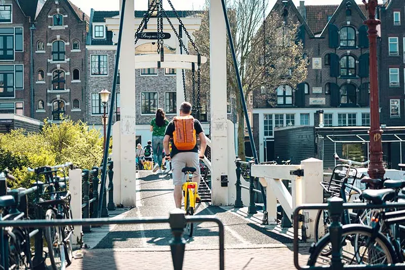 Cyclist on the historic Skinny Bridge in Amsterdam in summer